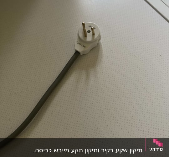 תקע חשמלי עם כבל על שולחן לבן